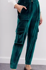 Pantalón babucha verde esmeralda de terciopelo con elástico en la botamanga, bolsillos plaqué en el frente con remaches metálicos y bolsillos cargo en las piernas.