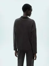 Sweater gris oscuro de tejido de punto acanalado, con cuello alto y mangas largas. Corte holgado.