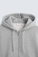 Sudadera negra relaxed fit confeccionada en tejido de algodón compacto con interior en rizo. Cuello con capucha ajustable y manga larga. Bolsillos frontales tipo canguro. Acabados en rib. Cierre frontal con cremallera.