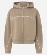 Saco con capucha color tostado, confeccionado en microfibra con algodón, con cierre frontal por cremallera y pipping contrastante en blanco en el pecho y mangas. Cuenta con ruedo y puños acanalados.