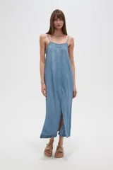 Vestido largo holgado de tela tipo denim o chambray, color azul claro, con tirantes finos y detalle de bordado o encaje en el escote. Presenta una abertura frontal central.