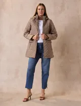 Campera capitoneada color beige, marca Weatherproof, con capucha desmontable, cierre central, bolsillos delanteros con cierre, tajo lateral con botones y forro interno a tono.
