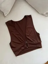Top corto marrón con escote en V y detalle de argolla metálica en el centro.