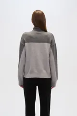 Sweater gris con cuello alto, diseño degradado y apliques de lentejuelas en el frente y las mangas.