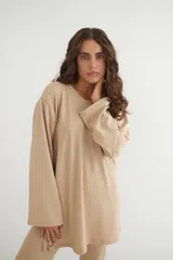 Conjunto verde oliva de punto morley, compuesto por un buzo de corte holgado con mangas largas y aberturas laterales, y un pantalón palazzo de tiro alto.