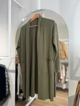 Saco largo color verde oliva, de tejido de punto, con cuello solapa y bolsillos frontales.