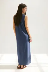 Vestido largo azul con cuello redondo y sisas con ribete color beige.