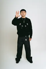 Pantalón de jean negro de corte baggy, con estampado de trigramas blancos en los bolsillos traseros.