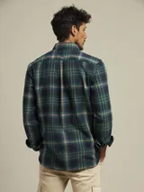 Camisa de cuadros en tonos rojos y verdes, con dos bolsillos frontales y manga larga.