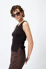 Musculosa de punto color beige, con textura acanalada y detalle de trenzado lateral ajustable.