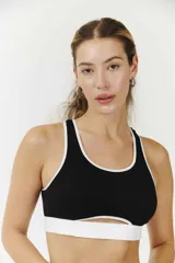 Top de microfibra negro con corte deportivo y tirantes blancos, sin aro y copas removibles.