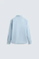 Camisa celeste de corte regular fit, confeccionada en popelín de algodón. Tiene cuello abotonado, manga larga con puños abotonados y cierre frontal con botones.