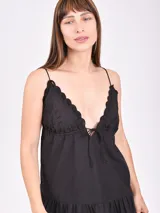 Vestido corto color crudo con breteles finos, escote en V con detalle de puntilla y falda con volado y bordado calado.