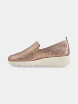 Zapatilla slip on de mujer color oro rosado metalizado, con puntera perforada y suela plataforma blanca gruesa.