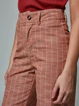 Pantalón de lino color ladrillo con estampado a cuadros blancos, de corte palazzo y tiro alto.