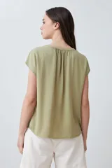 Blusa verde oliva de lyocell con cuello en V y mangas cortas.