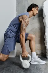 Short deportivo azul con calza biker interna, confeccionado en tejido funcional DryMove™ que ayuda a absorber el sudor. Cuenta con cintura elástica con cordón de ajuste, bolsillos laterales con cierre, abertura lateral en el bajo y logo estampado en la pierna.