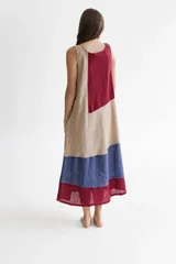 Vestido largo de lino color beige, con paneles en color rojo y azul. Diseño sin mangas, con escote cuadrado y bolsillos laterales.