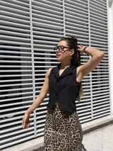 Chaleco negro de tela barbie con corte sastrero y calce al cuerpo.