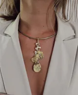 Gargantilla rígida dorada con dije colgante de tres hojas texturizadas y racimo de perlas pequeñas. Hecho en bronce.