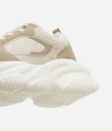Championes urbanos color beige con detalles en cuero sintético y gamuza. Presentan cordones blancos, suela chunky y recortes contrastantes.
