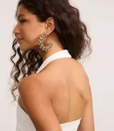 Blusa blanca de punto roma, con diseño de cuello halter que deja la espalda descubierta.