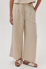 Pantalón de vestir color beige, de corte ancho y tiro alto, con cintura elástica ajustable con cordón.