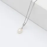 Collar con cadena tipo caja de plata 925 y dije colgante con una perla de río blanca de forma ovalada.
