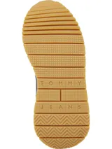 Zapatillas Tommy Jeans negras con detalles en blanco y suela color caramelo. Presentan paneles de cuero y gamuza, cordones negros y logo de la marca en el lateral.