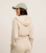 Campera deportiva color beige con rayas verticales finas, corte oversized, capucha con cordón ajustable, cierre frontal con cremallera, estampa bordada en el pecho, mangas largas ajustadas y bajo ajustado.