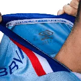 Camiseta de fútbol Umbro del Club Nacional de Football, modelo Away 3 temporada 2025. Diseño celeste con detalles en blanco, azul y rojo en cuello y mangas. Incluye logo de Umbro, escudo del club y sponsor Antel en el frente.