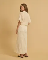 Falda larga color crema, de tela ligera con caída amplia y cintura elástica.