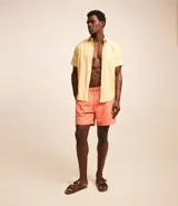 Camisa de hombre de manga corta color arena, confeccionada en lino y algodón. Tiene cuello camisero, corte clásico, cierre frontal con botones, un bolsillo en el pecho y ruedo recto.