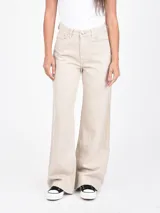 Jean de tiro alto, color beige claro con efecto desgastado, corte ancho y pierna acampanada.
