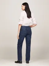 Jean de denim azul oscuro, de corte recto y talle medio, con efecto gastado en la parte delantera, cinco bolsillos y logo de Tommy Hilfiger bordado en el bolsillo trasero.
