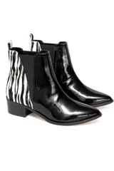 Bota corta negra de cuero charol con elástico lateral y detalle de estampado animal print en el talón.