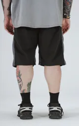 Bermuda negra con paneles laterales grises, cintura elastizada con cordón de ajuste y bolsillos laterales.