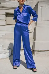 Pantalón palazzo de seda color azul eléctrico, tiro alto, con bolsillos laterales y traseros simulados. Cierre frontal con botón y cremallera.