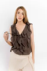 Blusa blanca de algodón con escote en V, volados en el frente y mangas cortas.