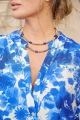 Collar corto de dos vueltas con cuentas cilíndricas plateadas y azules.