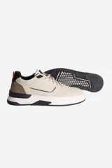 Zapatillas urbanas de cuero color beige con detalles en marrón, negro y naranja.