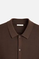 Camisa marrón de punto con viscosa, corte relaxed fit, cuello solapa, manga corta y cierre frontal con botones.