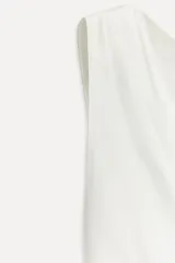 Top blanco de viscosa con escote asimétrico y manga sisa.