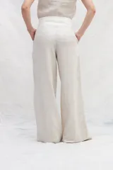 Pantalón de lino de tiro alto, con corte amplio a la cintura, confeccionado en dos colores: azul marino y marrón. Presenta un recorte delantero que estiliza la silueta. De calce cómodo.