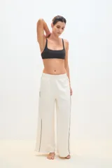 Pantalón palazzo negro con cintura elástica y una fina línea blanca vertical en los laterales.