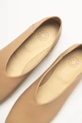 Chatas color beige de cuero vacuno, con talón suave y capellada metalizada.