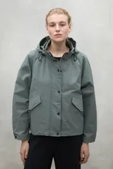 Chaqueta impermeable color verde grisáceo, con capucha ajustable y fit oversize.