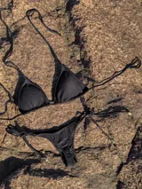 Conjunto de bikini con estampado animal print blanco y negro. El corpiño es de triángulos movibles con tiras finas para atar al cuello y a la espalda, con almohadillas desmontables. La bombacha es colaless con tiras finas para atar a los costados.