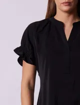 Blusa blanca de gasa marca Floral & Ivy, con cuello a la base y escote en V. Mangas cortas con elástico fruncido.