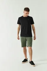 Bermuda de gabardina verde militar con estampado de lunares negros.